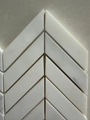 White marble chevron mosaic tile used on a luxury shower wall installation