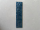 Close-up view of LUX Indigo 3x12 glass tile showing its rich blue decorative surface
