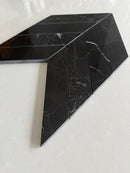 Nero Marquina chevron marble mosaic creating a sophisticated bathroom wall design